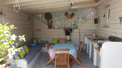 a patio with a table and chairs in a room at Villa Standing Piscine Chauffée in Gruissan