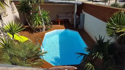 a small swimming pool in a yard with plants at Villa Standing Piscine Chauffée in Gruissan
