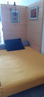 a bedroom with a large bed with a blue pillow at Chambre d'hôtes in Sigean