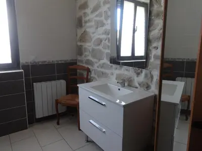 a bathroom with a sink and a stone wall at Charmant maison de village in Rieux-Minervois