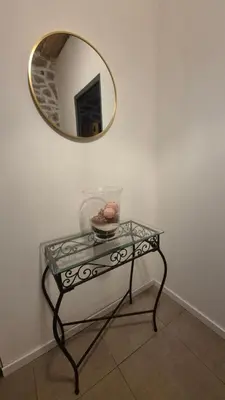 a glass table with a mirror on a wall at Charmant maison de village in Rieux-Minervois