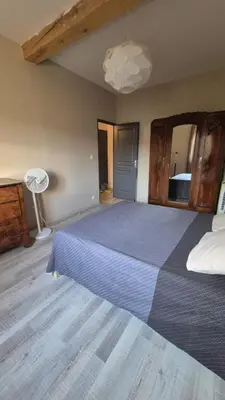 a bedroom with a large bed and a lamp at Charmant maison de village in Rieux-Minervois