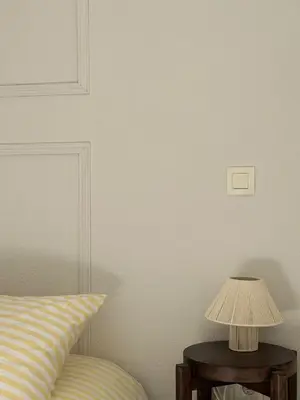 a lamp on a table next to a bed at Apt T2 moderne & lumineux in Narbonne
