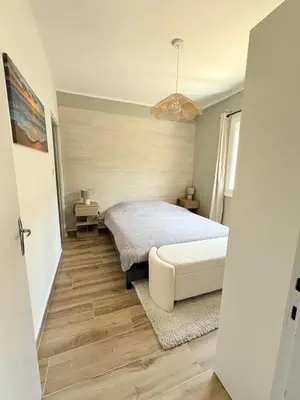 a bedroom with a bed and a table and a lamp at Appartement en centre-ville parking privé in Narbonne