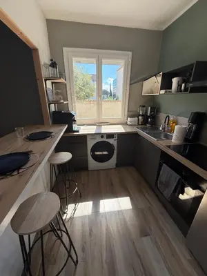 a kitchen with a washing machine and a window at Appartement en centre-ville parking privé in Narbonne