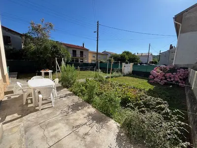 a patio with a table and chairs in a yard at Aux Tournesols in Lavelanet
