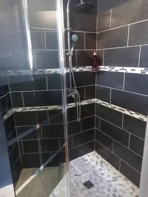 a shower with a glass door in a bathroom at Aux Tournesols in Lavelanet