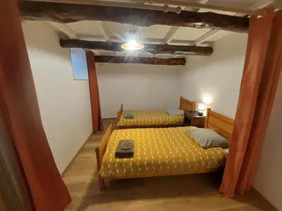 a bedroom with two beds in a room with a ceiling at Au petit hameau Cabrespine in Cabrespine