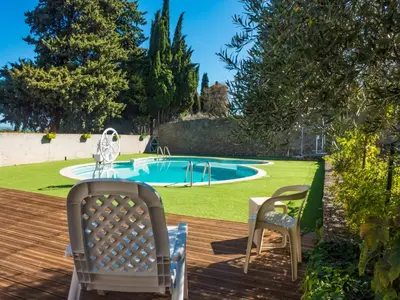 a deck with two chairs and a swimming pool at Cottage in Montbrun-des-Corbières in Montbrun-des-Corbières
