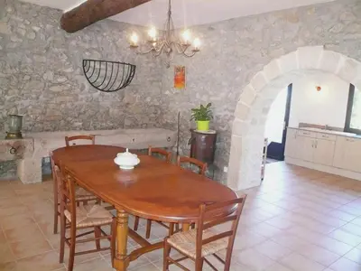 a dining room with a table and a stone wall at Cottage in Montbrun-des-Corbières in Montbrun-des-Corbières