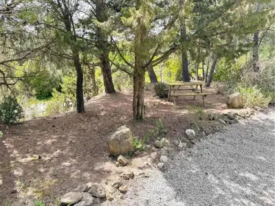 a picnic table in a park with trees and rocks at Cottage in Montbrun-des-Corbières in Montbrun-des-Corbières