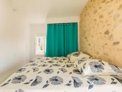 a bedroom with a bed with a green curtain at Holiday Home in Montouliers near Nature Reserve in Montouliers