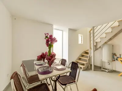 a dining room with a table with a vase of flowers at Holiday Home in Montouliers near Nature Reserve in Montouliers