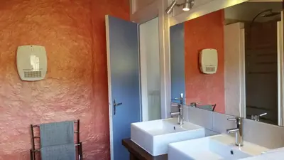 a bathroom with two sinks and a mirror at The Bergerie in Roquetaillade