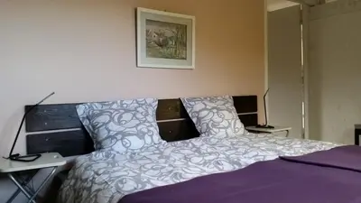 a bedroom with a bed with a purple comforter at The Bergerie in Roquetaillade