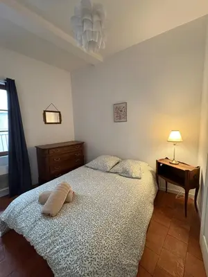 a bedroom with a bed and a table with a lamp at Le Capucin Terrace Hypercentre in Castres