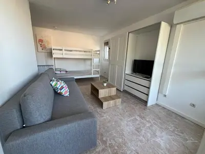 a living room with a couch and a television at Charmant studio grande terrasse in Gruissan