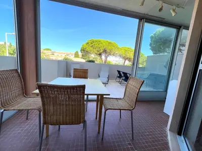 a dining room with a table and chairs on a balcony at Charmant studio grande terrasse in Gruissan
