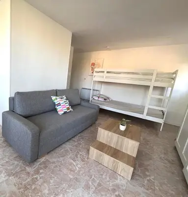 a living room with a couch and a bunk bed at Charmant studio grande terrasse in Gruissan
