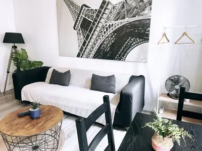 a living room with a couch and a picture of the eiffel tower at Appartements hyper Centre in Carcassonne