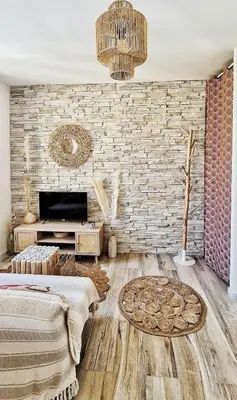 a living room with a brick wall and a tv at N2 Barbacane-Pieds Cité-Bohème Chic-Clim Mobile in Carcassonne