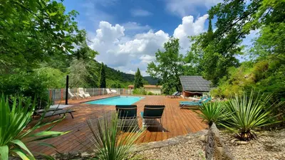 a deck with chairs and a swimming pool at The Grange in Roquetaillade