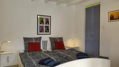 a bedroom with a bed with red and blue pillows at The Studio in Roquetaillade