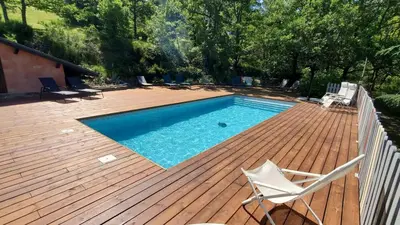 a swimming pool on a wooden deck with at The Studio in Roquetaillade