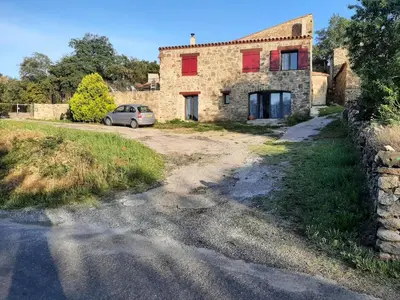 an old stone house with a car parked in front of it at Chez Louise in Arboussols