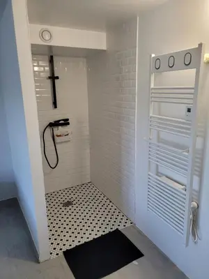 a bathroom with a shower with a cross on the wall at Chez Louise in Arboussols