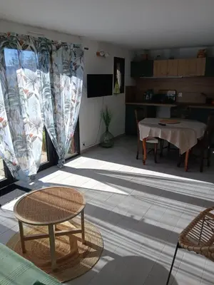 a living room with a table and a dining room at Chez Louise in Arboussols