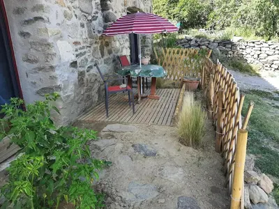 a table and an umbrella on a wooden deck at Chez Louise in Arboussols