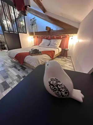 a bedroom with a bed and a bird vase on a table at House Patio Air Conditioning Elegant Decoration in Carcassonne