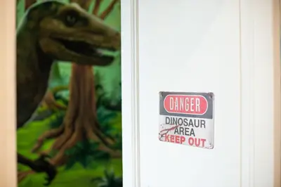 a sign that reads danger dinosaur area keep out at Qualys Cinema-Parking & View Square in Carcassonne