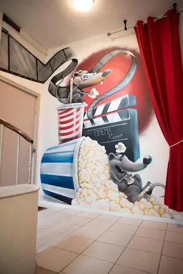 a room with a wall with a baseball mural at Qualys Cinema-Parking & View Square in Carcassonne