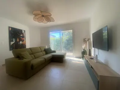 a living room with a couch and a tv at Maison Gérard Philippe in Carcassonne
