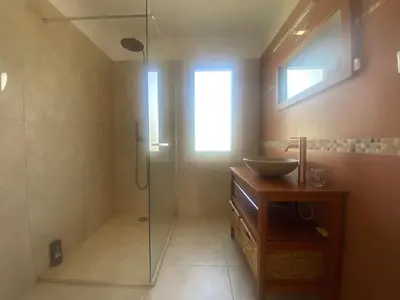 a bathroom with a glass shower and a sink at Maison Gérard Philippe in Carcassonne