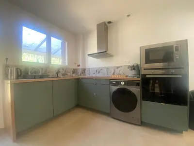 a kitchen with a washing machine and a microwave at Maison Gérard Philippe in Carcassonne