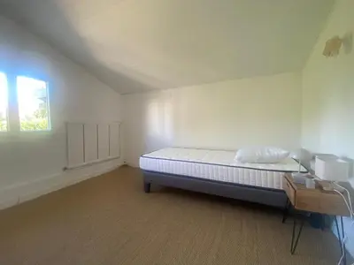 a white room with a bed and a window at Maison Gérard Philippe in Carcassonne