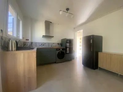 a large kitchen with a refrigerator and a stove at Maison Gérard Philippe in Carcassonne