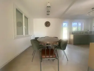 a dining room with a wooden table and green chairs at Maison Gérard Philippe in Carcassonne
