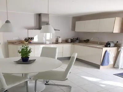 a white kitchen with a white table and chairs at Villa in Saint-Couat with Private Pool in Saint-Couat-dʼAude