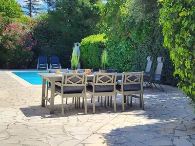 a wooden table and chairs sitting next to a pool at Villa in Saint-Couat with Private Pool in Saint-Couat-dʼAude