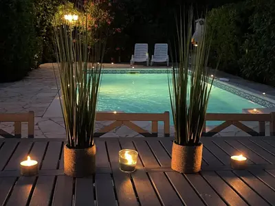 a table with candles and plants and a swimming pool at Villa in Saint-Couat with Private Pool in Saint-Couat-dʼAude