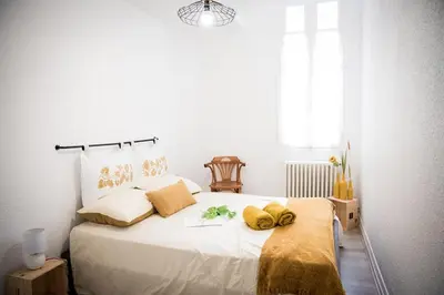 a bedroom with a large white bed with yellow towels on it at Qualys Vignoble parking, square view, close to city in Carcassonne