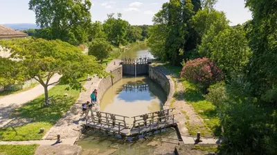 an aerial view of a canal with people walking along it at Qualys Vignoble parking, square view, close to city in Carcassonne