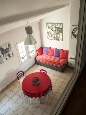 a living room with a red couch and a table at Le Loft De La Robine 110m2 in Narbonne