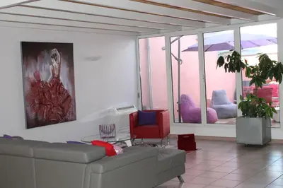 a living room with a couch and a red chair at Le Loft De La Robine 110m2 in Narbonne