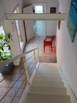 a staircase in a house with a red chair at Le Loft De La Robine 110m2 in Narbonne