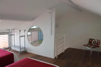 a room with a mirror and a bed and a chair at Le Loft De La Robine 110m2 in Narbonne